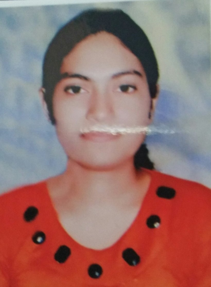 Portrait of Dr. Kapoor wearing traditional attire with academic books in background